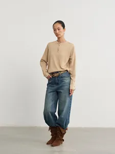 Modèle portant un jean en denim délavé à taille haute et jambe large de style rétro.
