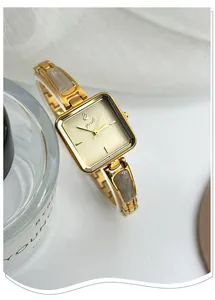 Detailed view of an elegant gold square bracelet watch featuring stylish grey marble accents
