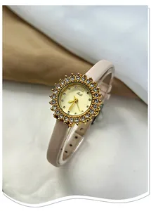 Close-up of elegant sunflower golden watch with crystal halo and pink leather strap