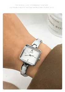 Detailed view of an elegant square silver women's watch with white marble inlay strap.
