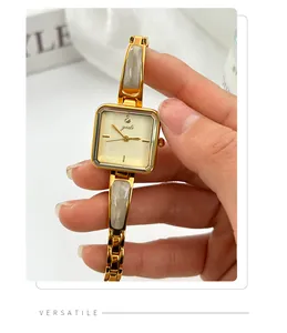 Close-up of an elegant gold square quartz watch with marble link bracelet and gedi logo