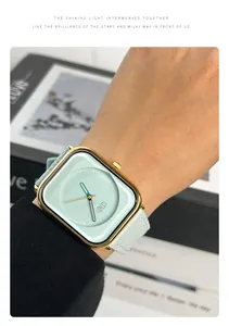 Close-up detail of women's square gold watch with mint green dial and white leather strap