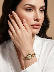 Gros plan d'une montre GEDI dorée ovale sertie de diamants avec chiffres romains au poignet