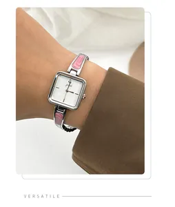 Close-up of elegant square silver quartz watch with pink marbled bracelet detail