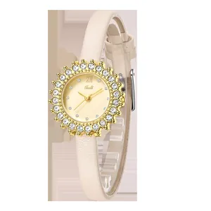 Close-up of a gold ladies' quartz watch with rhinestone sun bezel and cream leather strap
