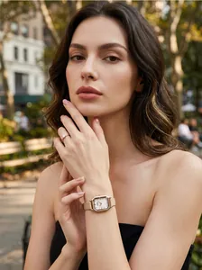 Elegant woman wearing a GEDI square dial watch and rose gold diamond ring in city park