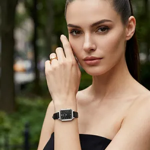 Elegant women's square quartz watch with black leather strap and silver case on model.