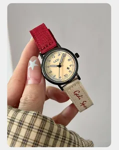 Close-up macro shot of fashionable women's quartz watch with red and beige nylon strap