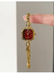 Close-up detail of elegant gold quartz watch for women with red dial and vintage design