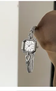 Detail shot of elegant silver square quartz watch with a delicate link bracelet for women