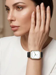 Detail of square gold watch with black leather strap worn by female model