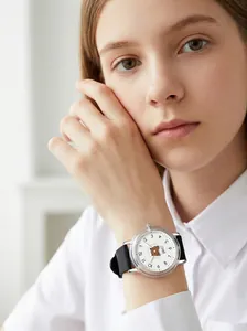 Close-up of a girl wearing a cartoon bear quartz watch with a black silicone strap.