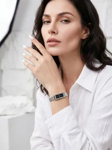 Elegant minimalist silver steel band quartz watch with black rectangular dial on model