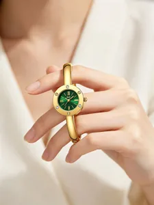 Detailed shot of gold bangle watch with green sunburst dial and Roman numerals