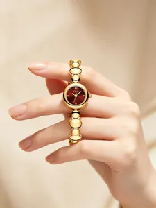 Primer plano del reloj retro GEDI para mujer con esfera roja y cadena de metal oro