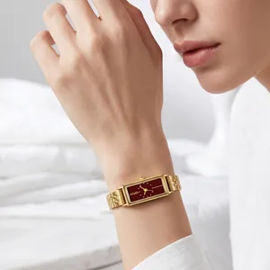 Elegant GEDI gold rectangular quartz watch with a wine red dial worn on a female wrist.
