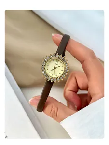 Close-up of gold sunflower bezel watch with sparkling rhinestones and brown leather strap