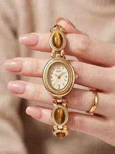 Close-up of GEDI vintage oval watch featuring tiger-eye stones on a gold bracelet