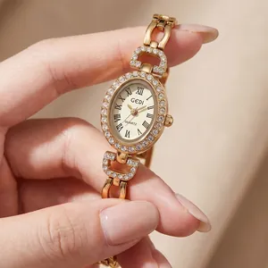 Élégante montre GEDI ovale dorée pour femme avec lunette strass et chiffres romains