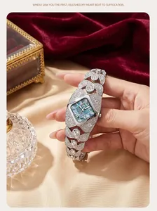 Close-up of luxurious diamond-encrusted bracelet watch held by hand on velvet.