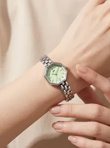 Close-up of a women's silver octagonal quartz watch with a mint green dial on a wrist.