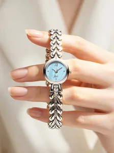 Close-up of Gedi small round watch with blue mother-of-pearl dial and chain strap.