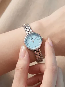 Close-up of elegant women's watch with light blue octagonal dial and silver steel strap