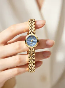 Detailed macro view of gold quartz watch featuring a blue mother-of-pearl dial and leaf links