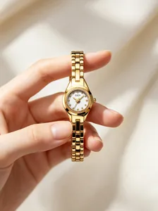 Elegant close-up of GEDI gold women's watch with white dial held in a lady's hand