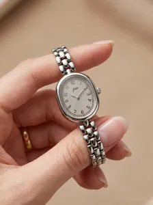 Close-up detail of JW vintage oval quartz watch with silver link strap and numeric dial