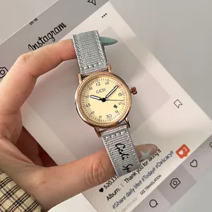 Elegant ladies quartz watch with rose gold case and grey woven strap on cream dial