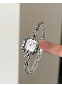 Detail view of a vintage silver square quartz watch with a metal mesh bracelet.