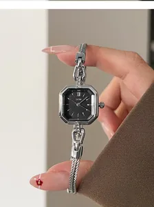 Close-up of a vintage silver square women's quartz watch with black dial and chain strap