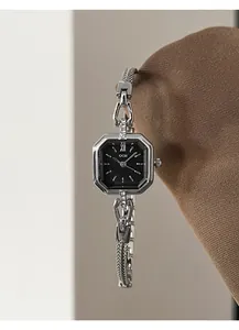 Close-up of elegant square silver alloy quartz watch with black dial and stone accents.
