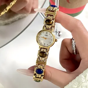 Vintage ethnic style gold-toned bracelet watch with colorful stones and pearl dial