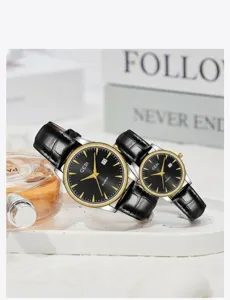 Detailed shot of couple's quartz watches with black leather straps and gold accents