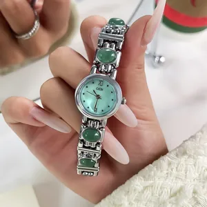 Macro view of GEDI retro bracelet watch featuring elegant green stones and silver band.