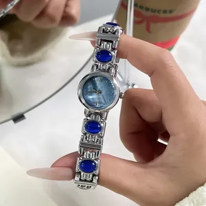 Detail view of GEDI silver bracelet watch with blue stones and mother-of-pearl dial