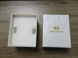 Gros plan d'une boîte à montres carrée blanche avec mousse et logo BESTWIN doré