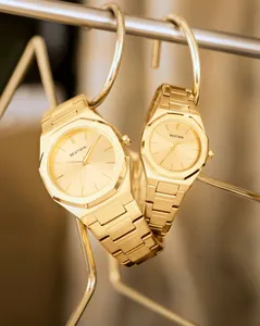 Primer plano profesional de relojes de cuarzo dorados BESTWIN para pareja con biseles octogonales