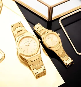 Elegantes relojes de pareja dorados con caja octogonal BESTWIN en foto de detalle