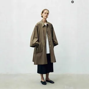 High-waisted black wool wide-leg pleated trousers styled with a trench coat