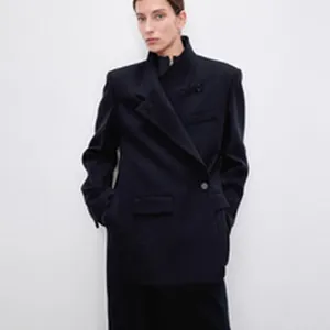 Full view of minimalist black wool oversized blazer and tailored trousers suit.