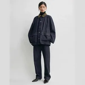 Full body view of woman wearing oversized dark denim jacket and straight leg jeans.