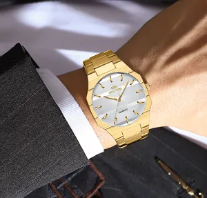 Detail of gold BESTWIN men's quartz watch with textured silver dial on wrist.