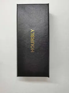 Gros plan d'un coffret cadeau montre noir texturé avec détail du logo doré HOURSLY