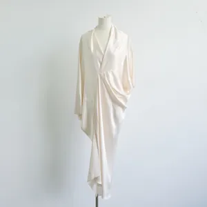 Elegante crèmewitte acetaatjurk met V-hals en gedrapeerd wikkelontwerp op een etalagepop