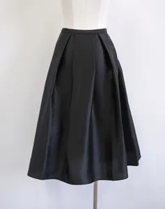 Elegant black silk wool blend A-line skirt featuring sophisticated pleats and macro texture.