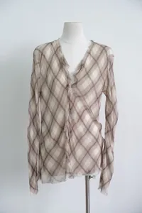 Detailed view of brown plaid sheer blouse with frayed V-neck and asymmetrical hem