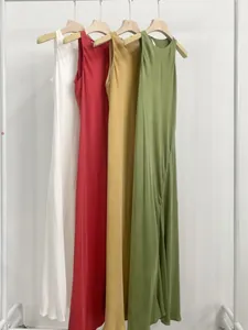 Quattro eleganti abiti minimalisti in vari colori su un appendiabiti bianco pulito.